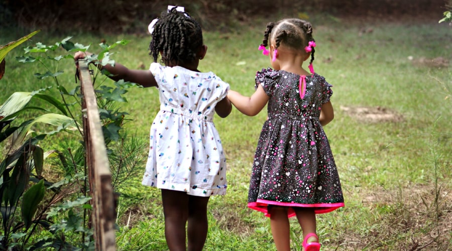 Two girls walking holding her hands