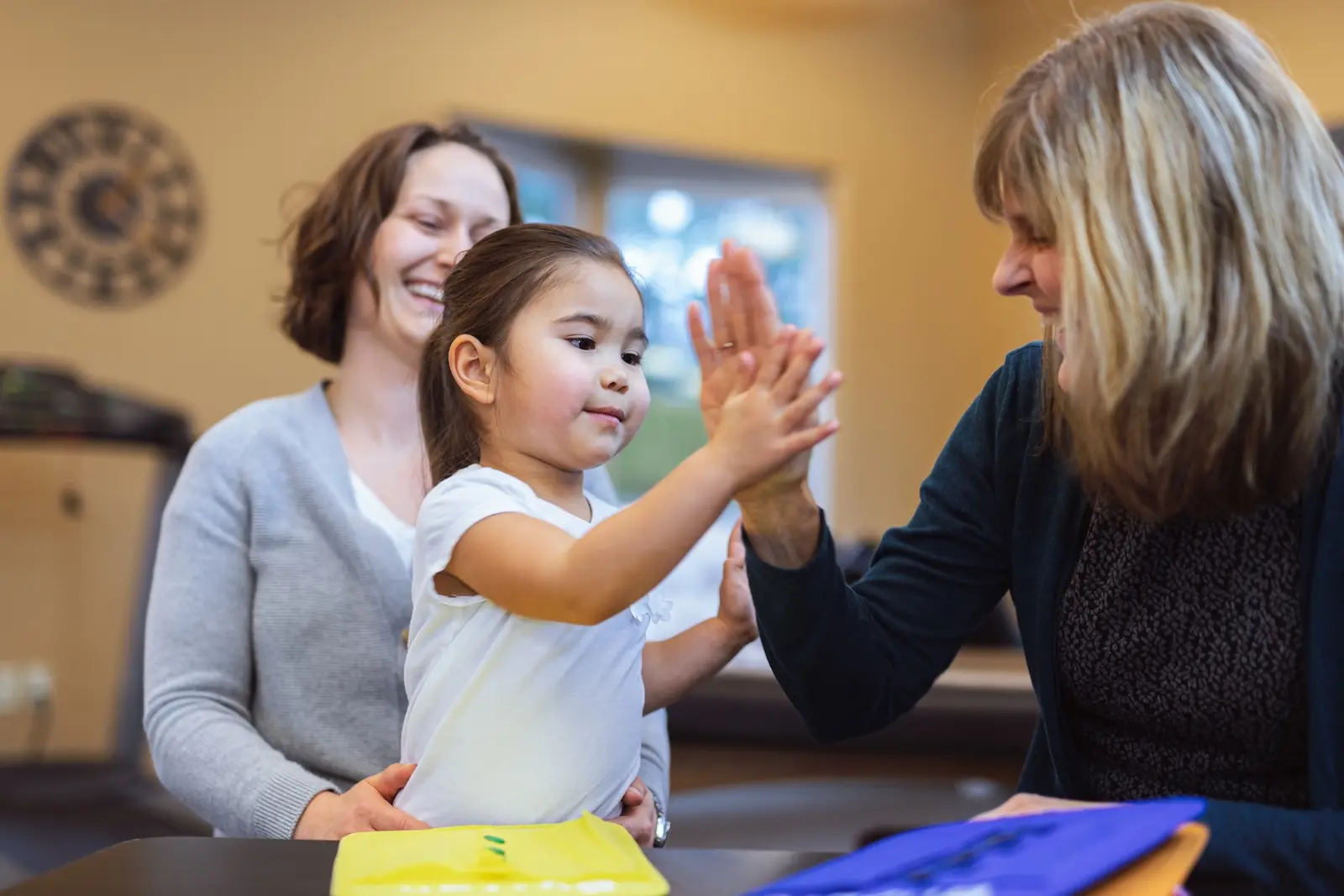 Nursery employees playing with a little girl