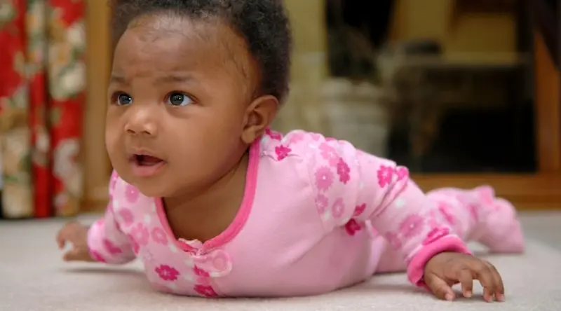 Baby girl lying down on bed doing some physical activity