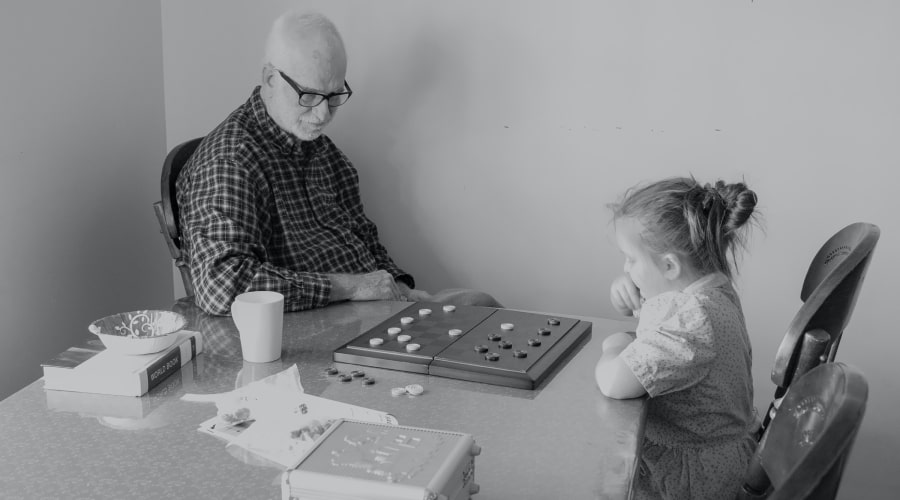 Man And Little Girl Playing Checkers