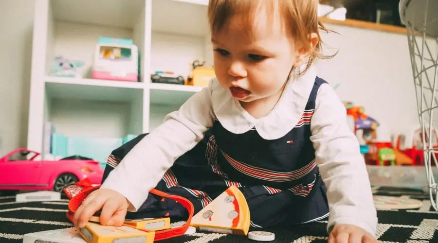 Toddler playing with wooden toys