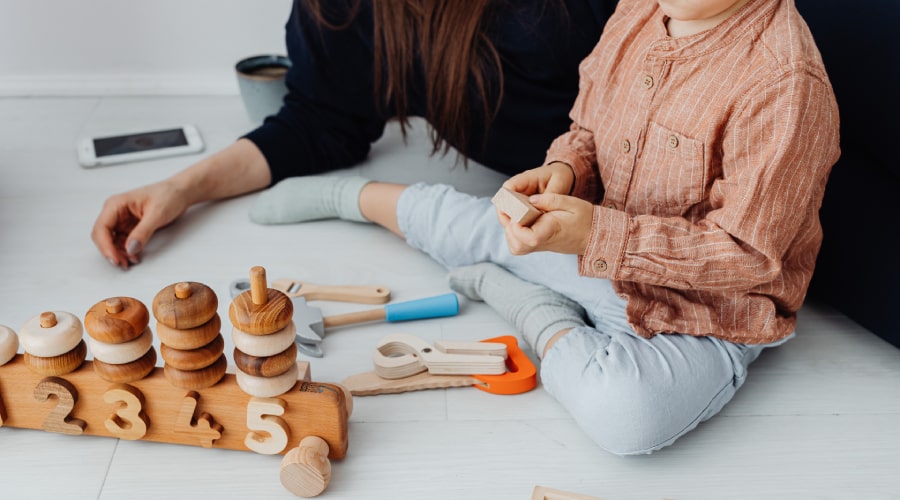 woman and child playing with wooden toys