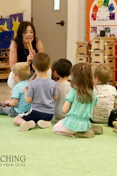 nursery teacher playing with a group of kids