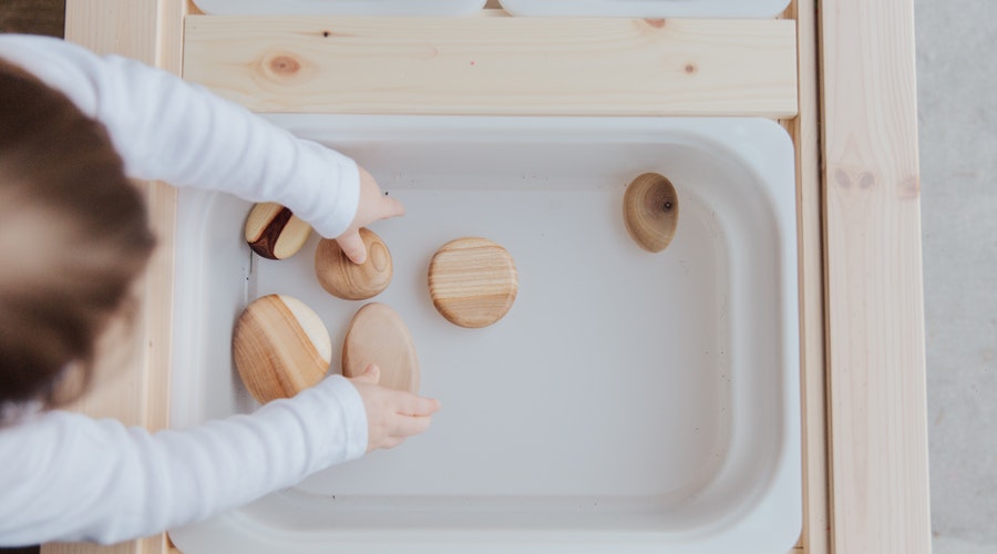 A child plays with wooden loose parts in an early years etting