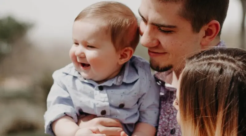 Young family holding a smiling baby