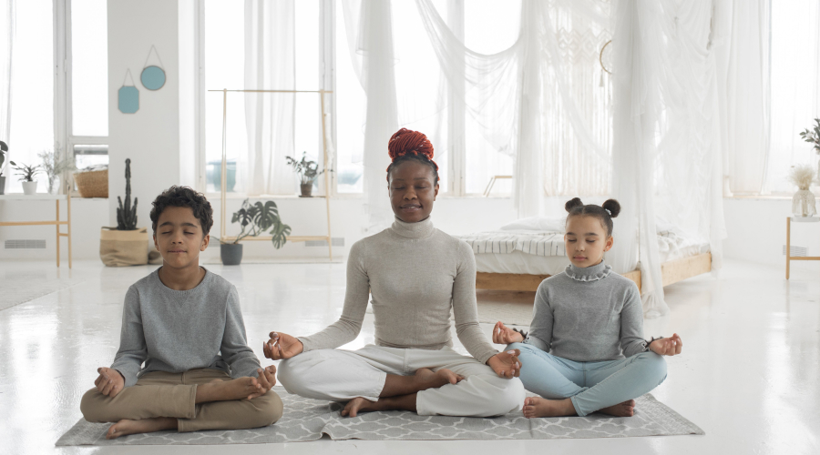 An EY educator and two children practice meditation