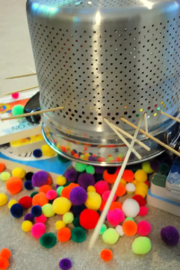 a colander and pompoms