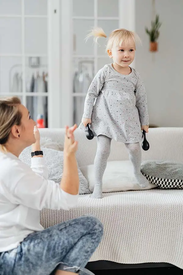 Little girl dancing on sofa