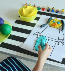 Outline of lego man filled with play dough