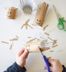 Picture of a kid cutting paper rolls