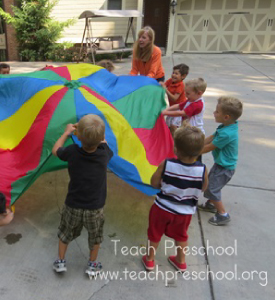 A group of kids playing with a parachute