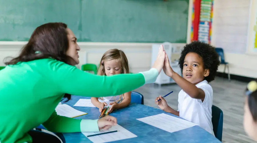 preschool teacher high-fiving her student