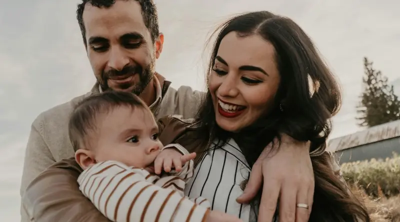 mom and dad cuddling their baby