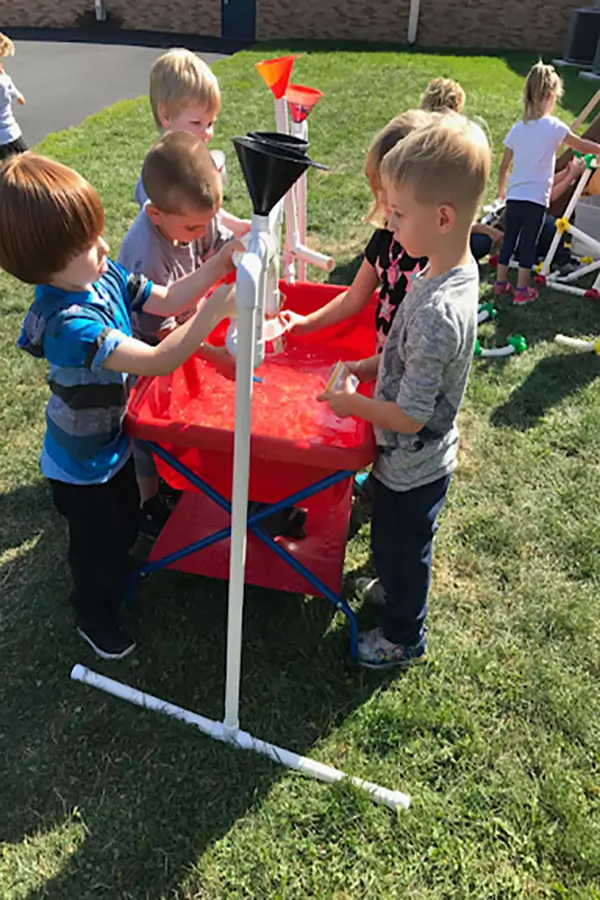 Boys playing outside with pipes and tubes