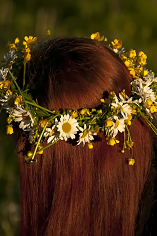 A girl wears a crown made of natural materials