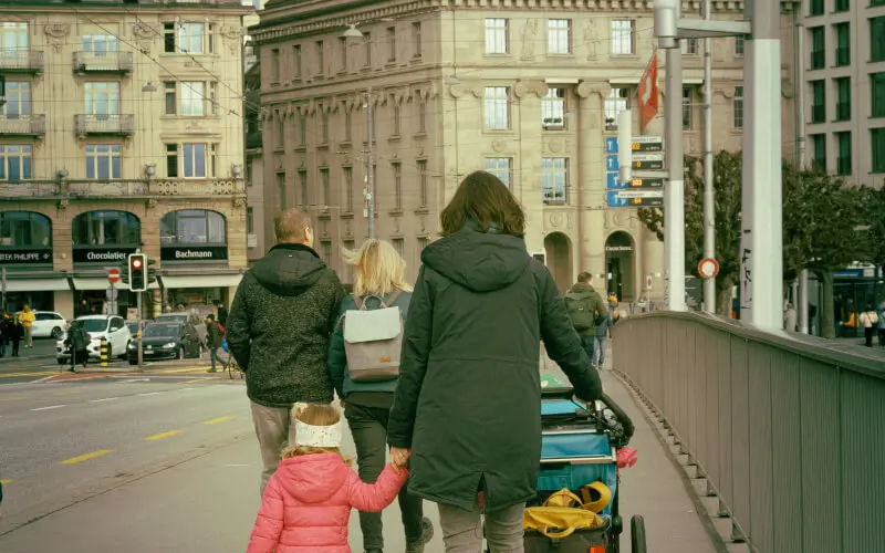 mom pushing a stroller with her daughter in europe