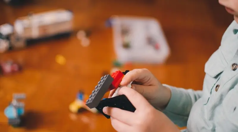 child builds structure with lego