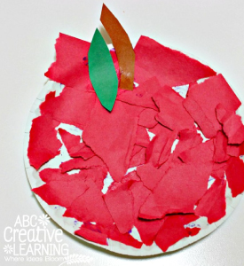 Pieces of red paper on an apple shaped paper plate.
