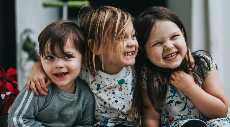 3 kids hugging and laughting