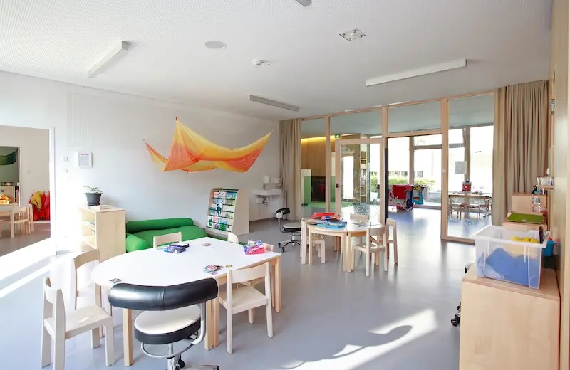Ein hell erleuchtetes Kinderzimmer mit kleinen Stühlen und Spielzeug