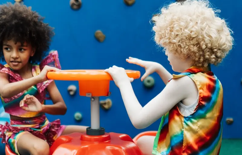 Two Early Years children play on a round-about