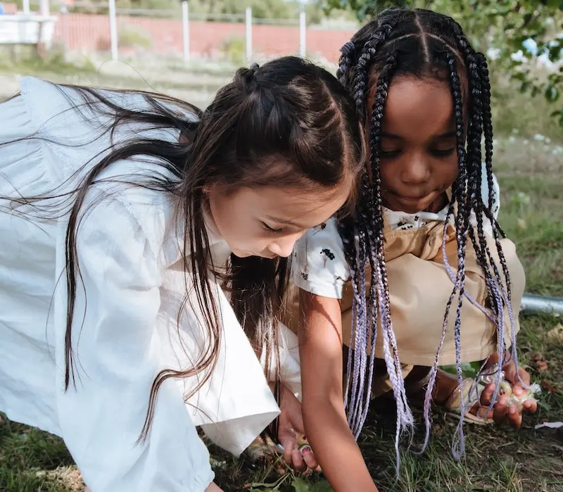 Two Early Years children play in a nursery garden