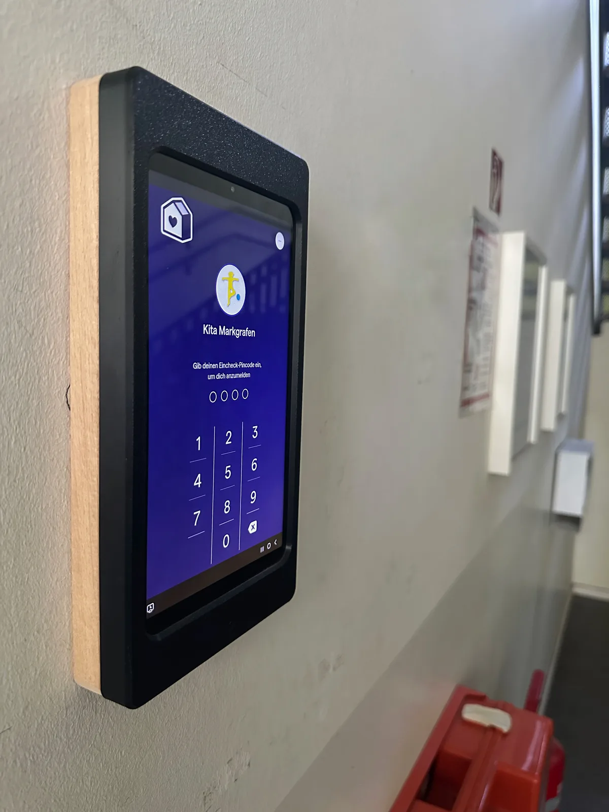 Eincheck-Terminal der Famly Kita-App an der Wand einer Kindertagesstätte des Mittelhof e.V.