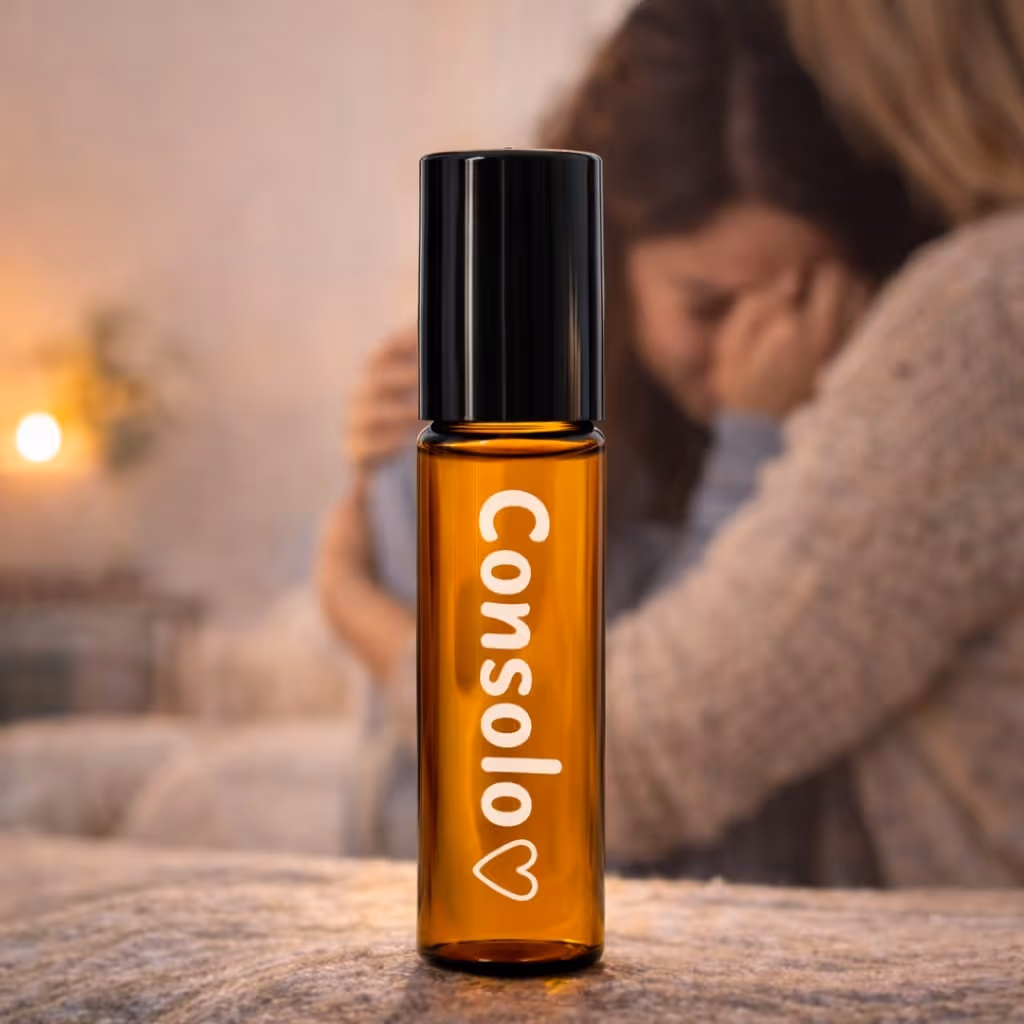 Frasco roll-on âmbar com rótulo Consola e um coração; fundo desfocado mostra mulher a consolar uma criança.