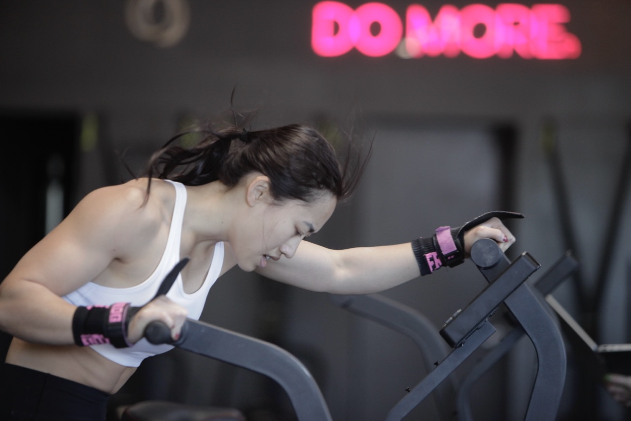 Woman in sportswear biking during a workout in a crossfit gym in west los angeles