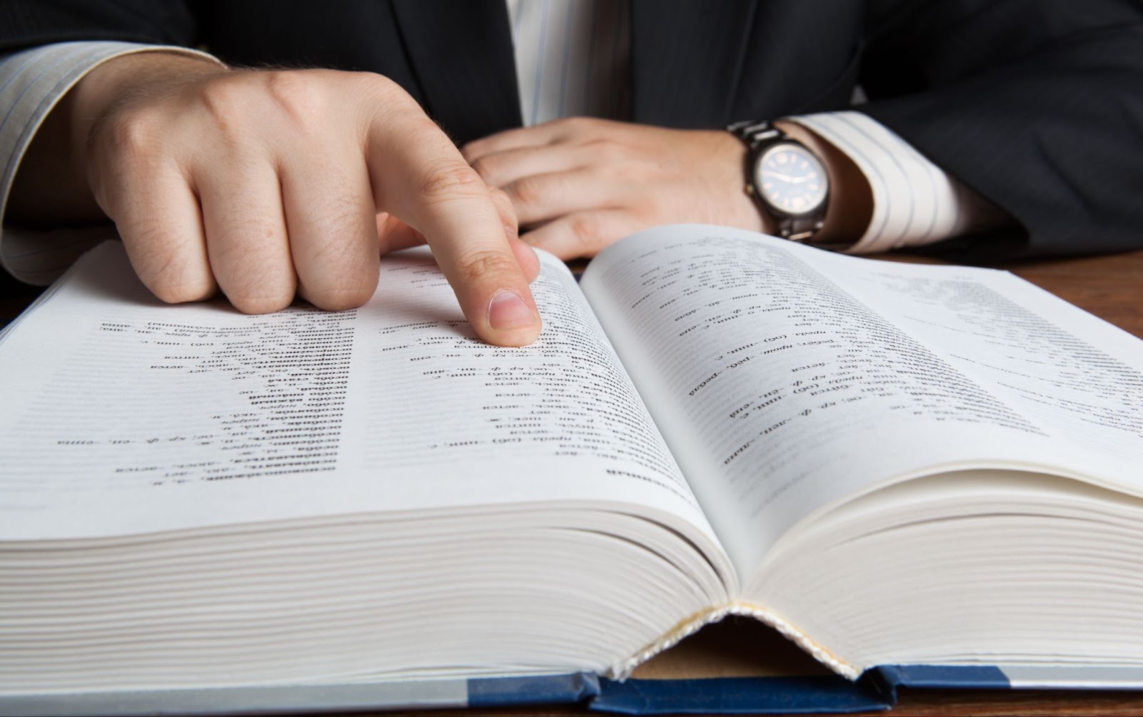 A person pointing to a page in a book.