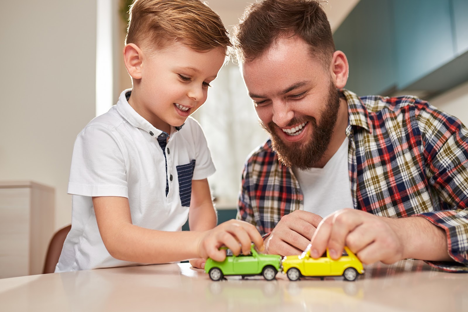 A father and son playing with toy cars