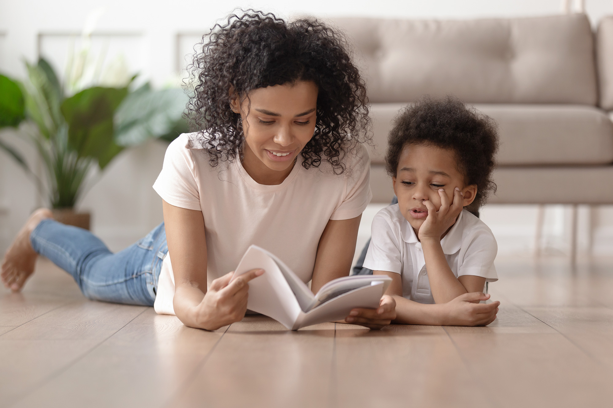 Mom with Child Sitting on Floor and Reading a Book Together