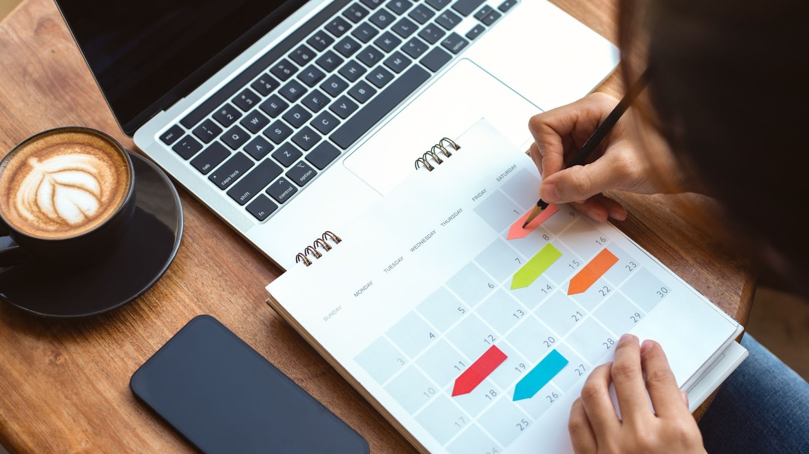 A person writing in their planner.