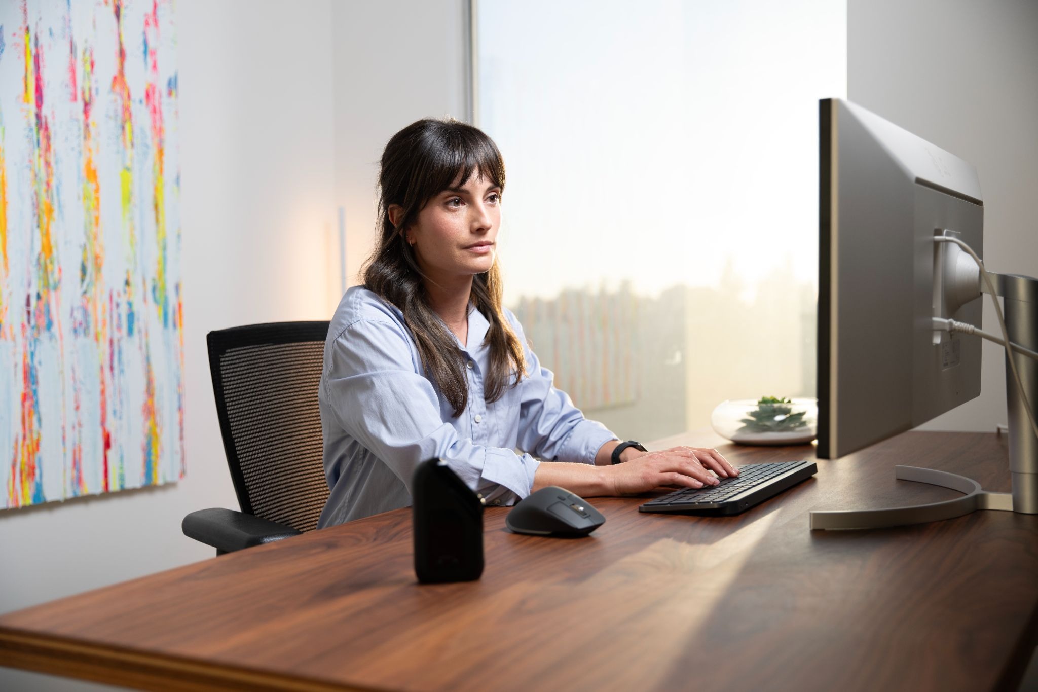 A woman sitting at her desk in front of her computer and typing.