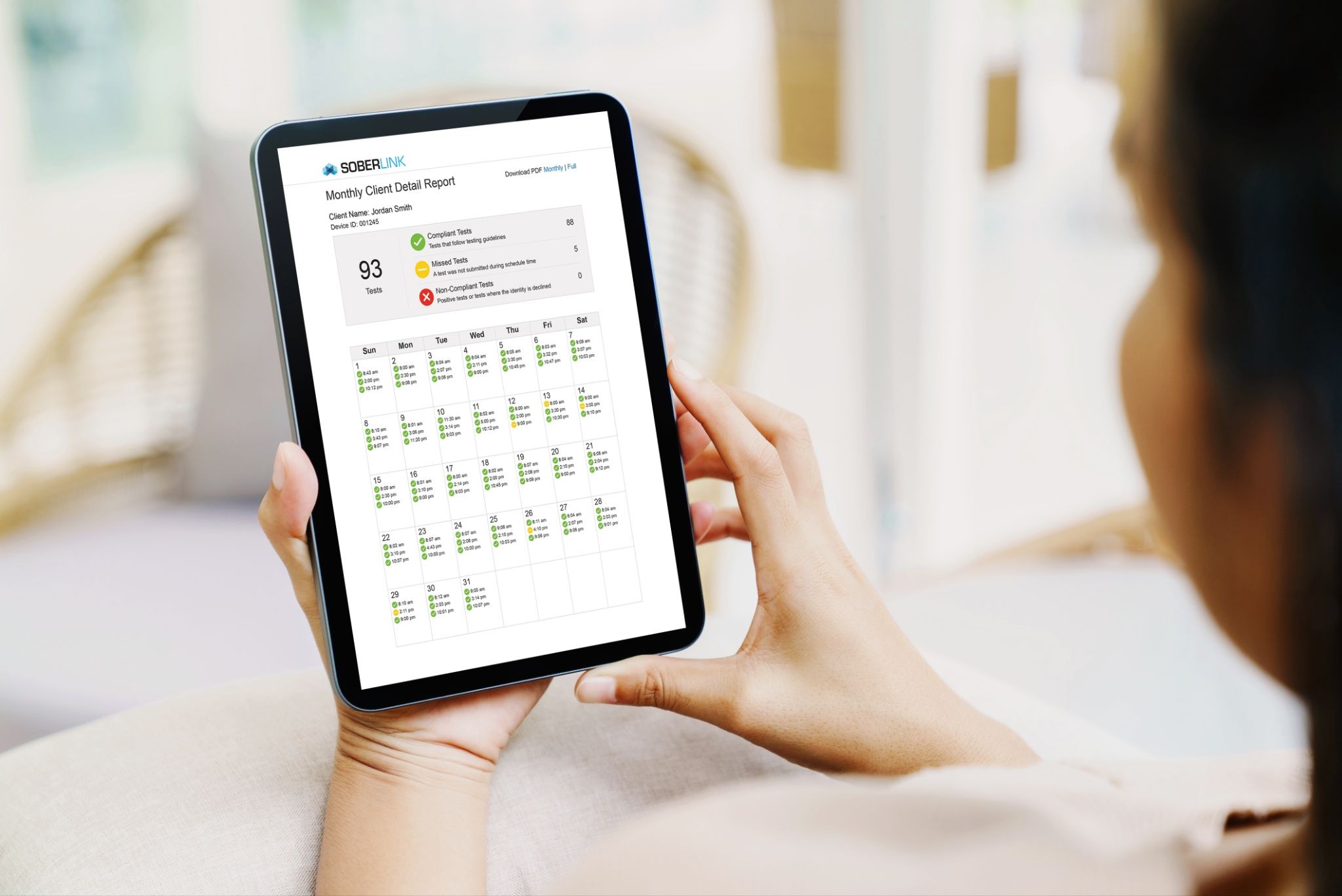 A woman reviewing Soberlink's monthly reporting on her tablet.