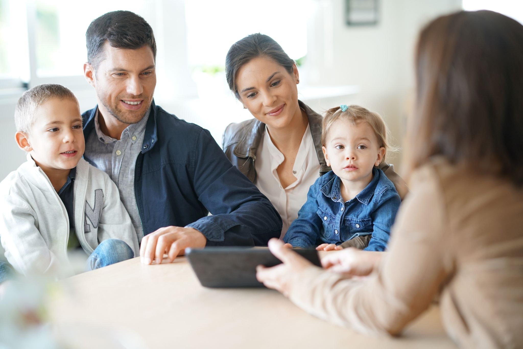 A family that consists of mother, father, son, and daughter, talking to a treatment provider.
