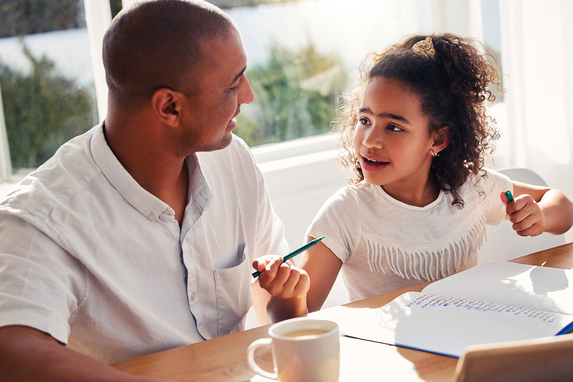 A father helping his daughter with homework.