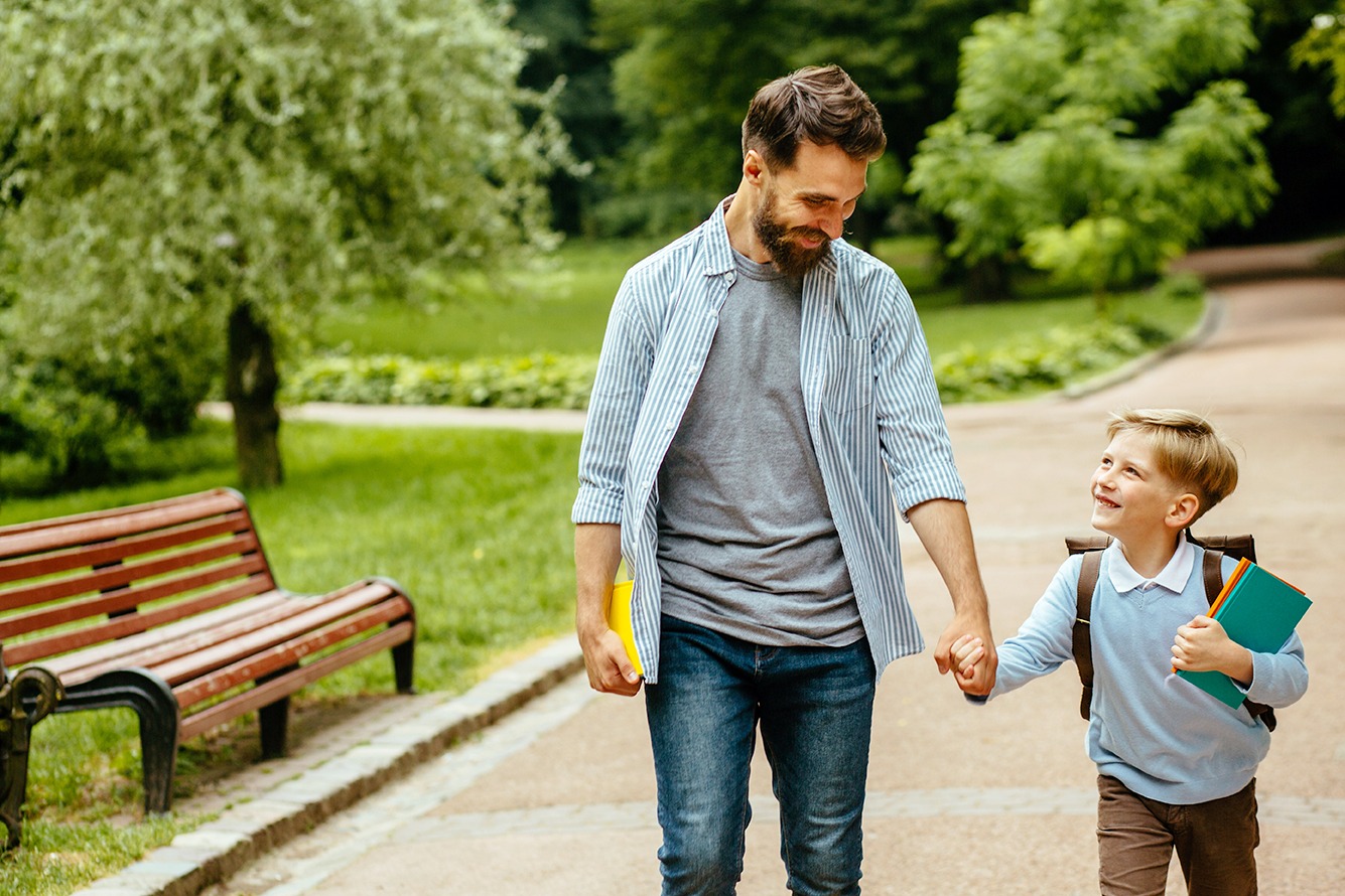 A father and his young son holding hands.