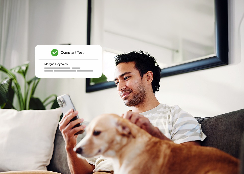 A man sitting on the couch and looking on his phone.