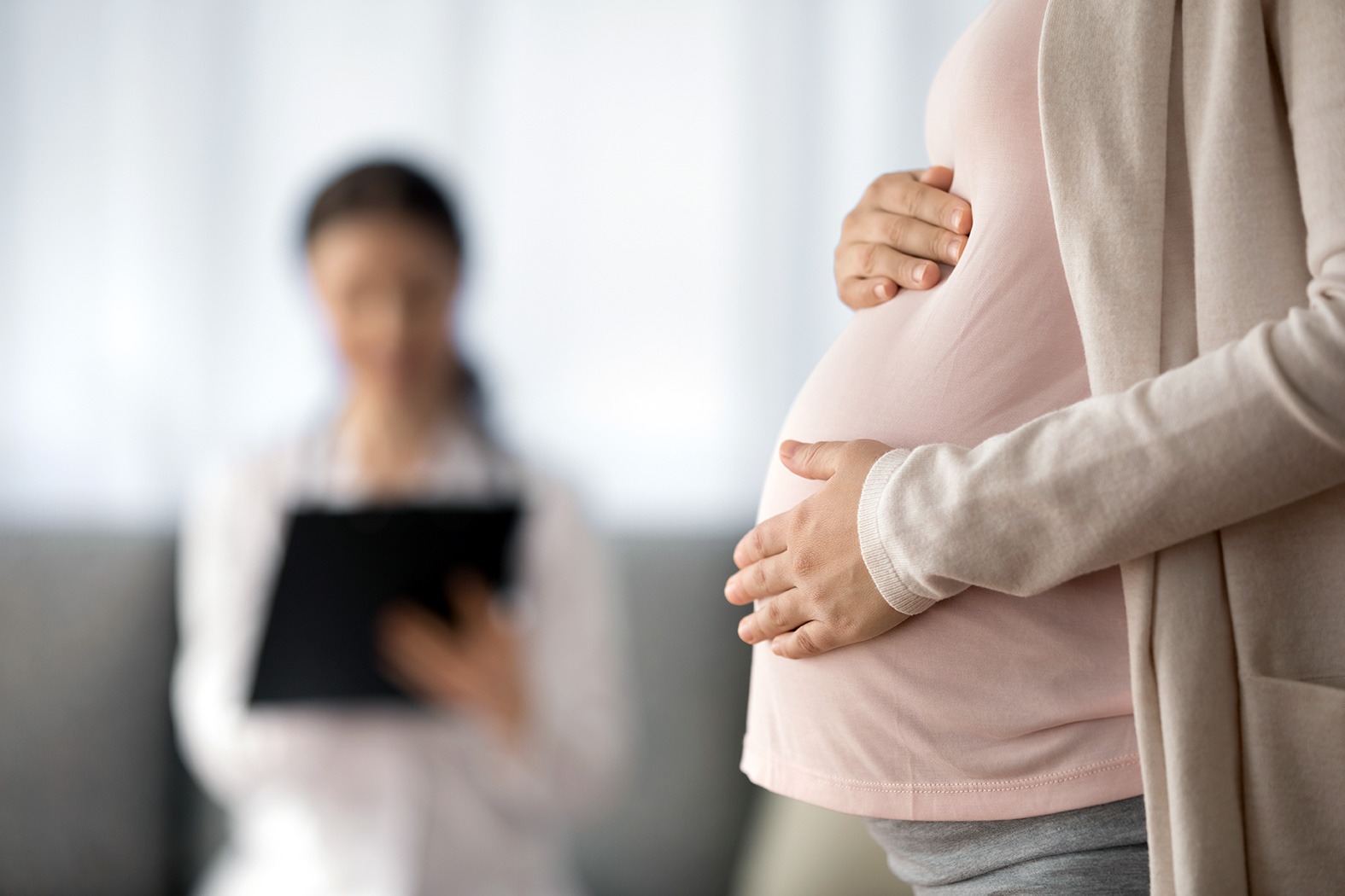 A pregnant woman holding her stomach.