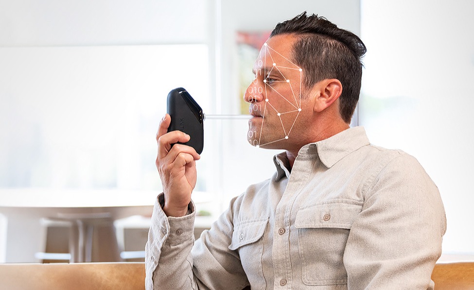 A man blowing into a Soberlink device.