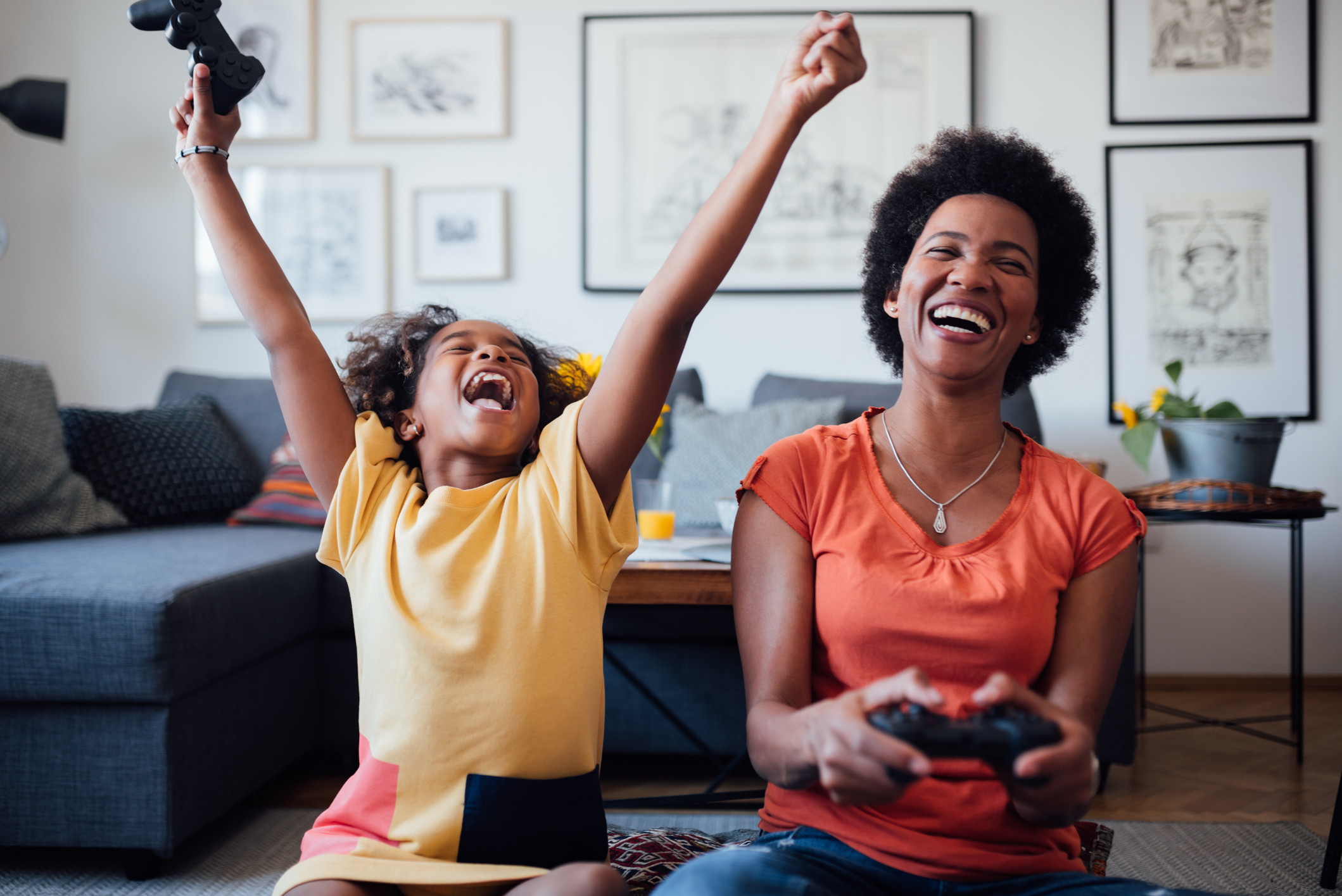Joyful mom playing video games with young son