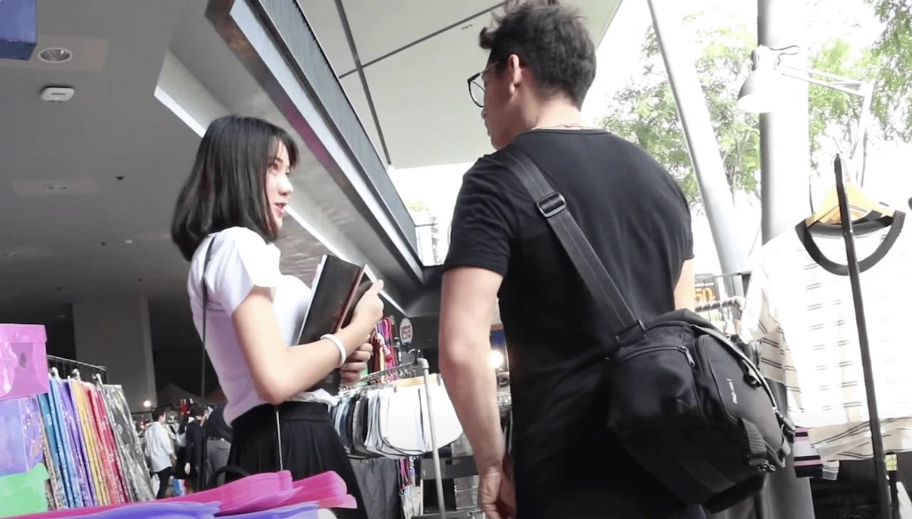 foreigner talking to a young Thai female student at a campus in Bangkok 