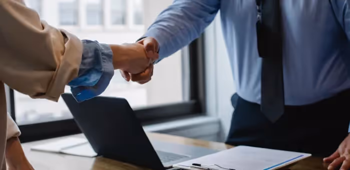 A manager and employee shaking hands 