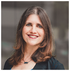 White woman with brown hair and warm eyes smiles at camera