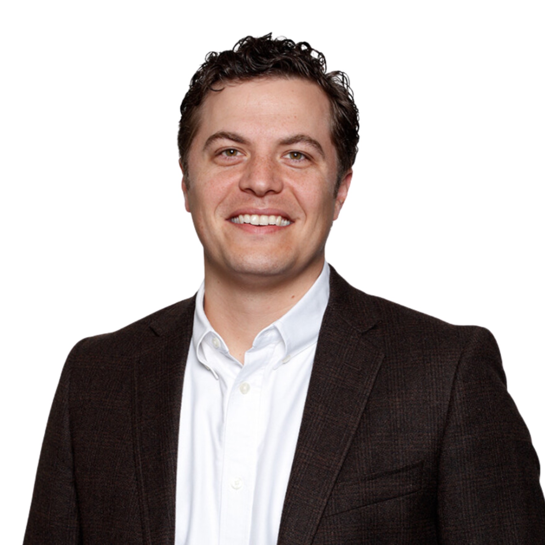 White man in black suit and white shirt smiling.