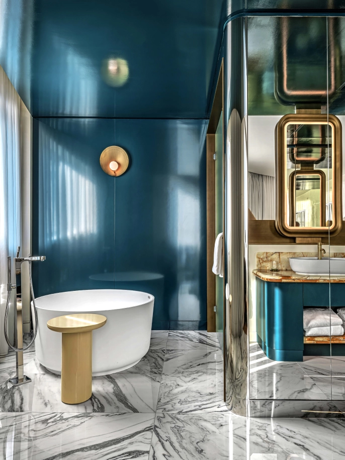 AvroKO's take on the suites give each their own personality. All of them lean into the Fantastical Garden concept pillar with a mixture of materials, pattern and color. Still clean and modern, nuance remains with tremendous curving lines throughout, paying homage again to Art Nouveau. There is also a mixture of prints that define the furniture and floor coverings, which give some contrasting play to the signature green throughout. Pops of gold and custom brass inlays throughout the space bring it all together. 