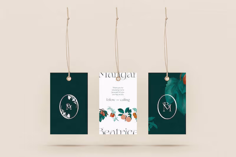 Three hanging gift tags with floral designs and initials 'BM' on dark green and white backgrounds.