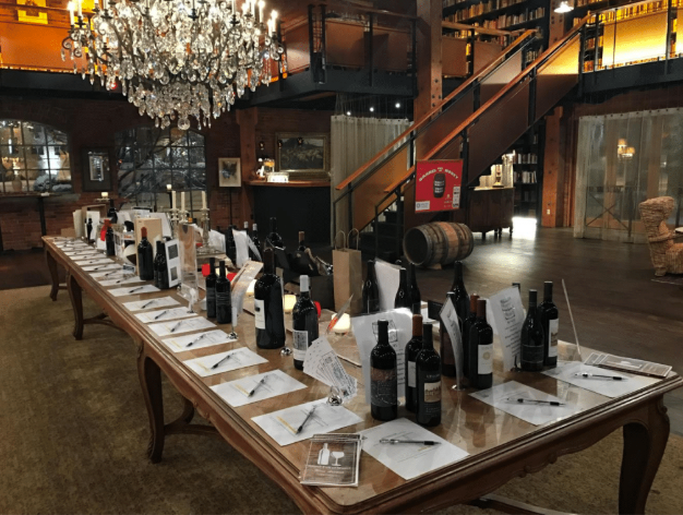 Silent Auction items on a table at the center of a tasting room.