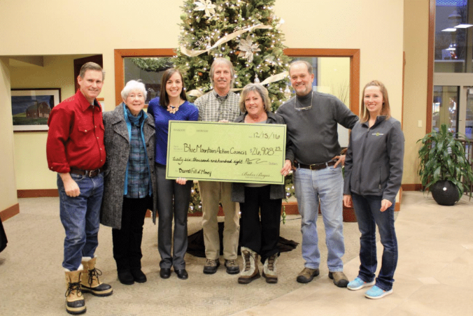 A group of people hold a large check.